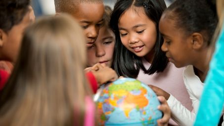 Elementary school kids exploring the globe.